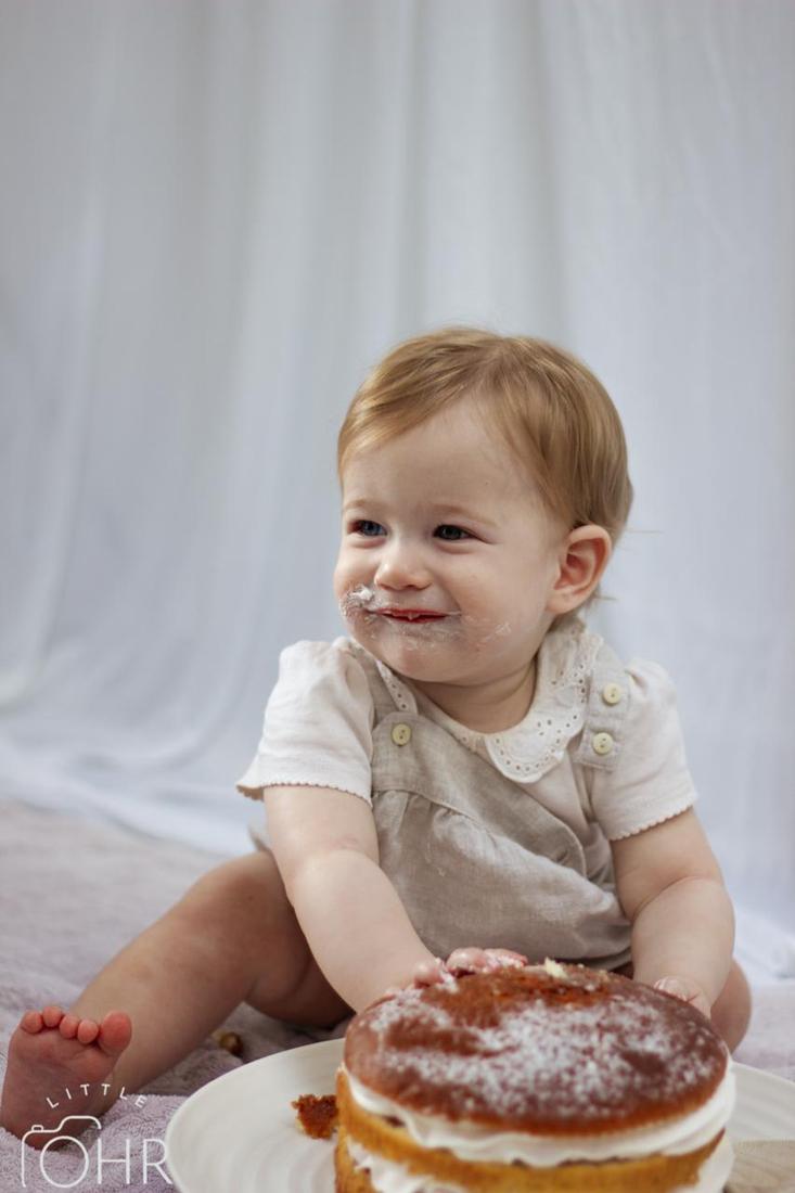 Baby tasting cake at a cake smash photoshoot