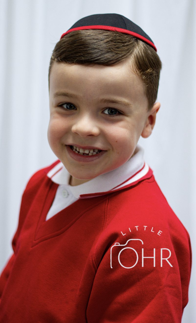 Smiling boy in a kippah and red school jumper