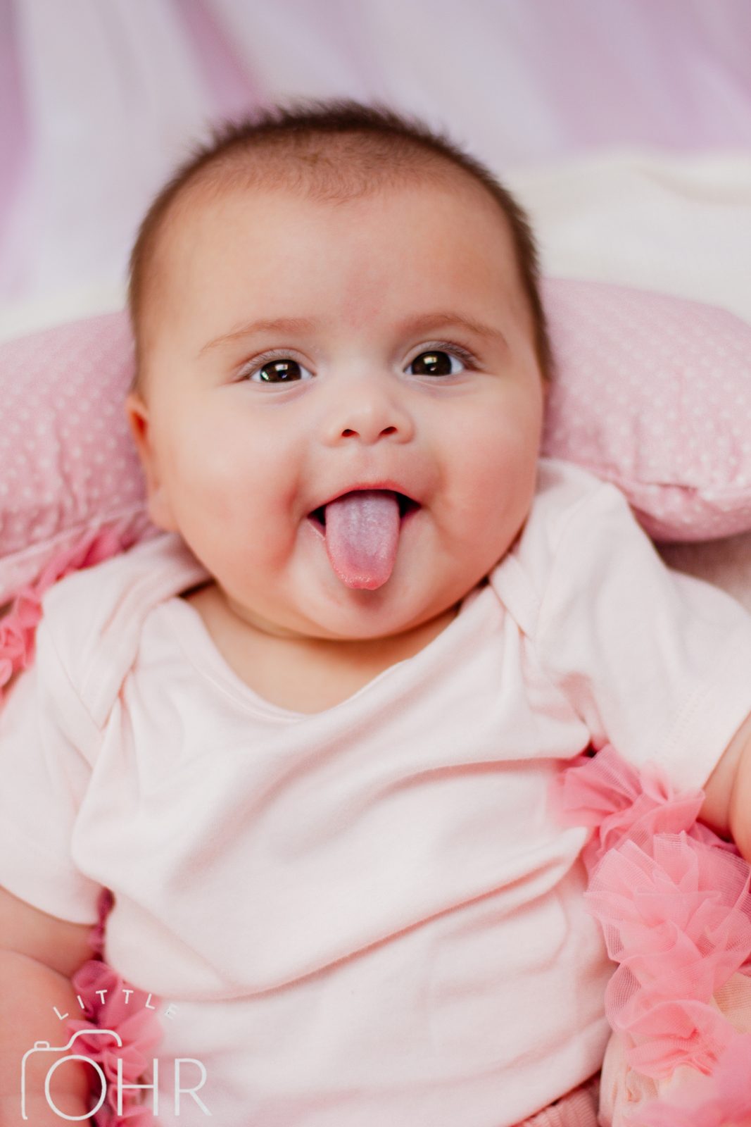 Smiling baby girl sticking her tongue out