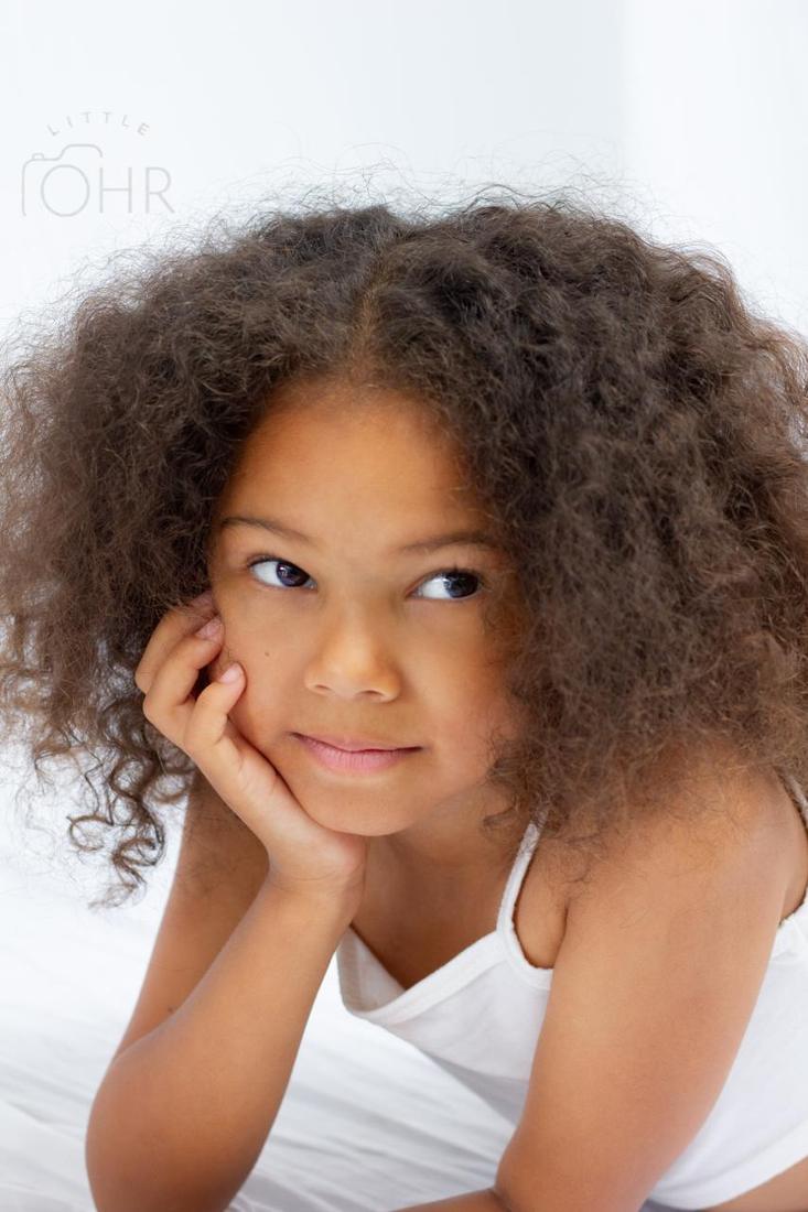 Thoughtful portrait of a girl resting her chin on her hand