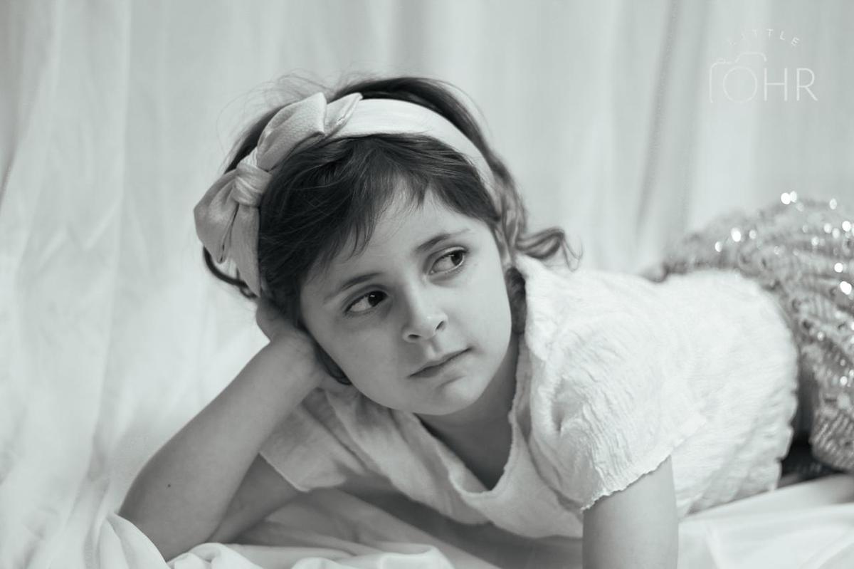 Black and white portrait of a girl with a bow headband