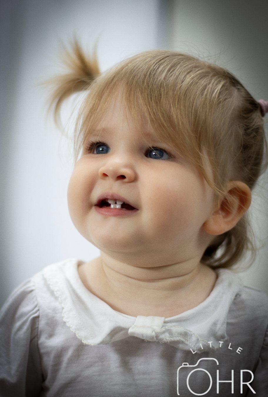 Smiling toddler girl with her hair in a topknot